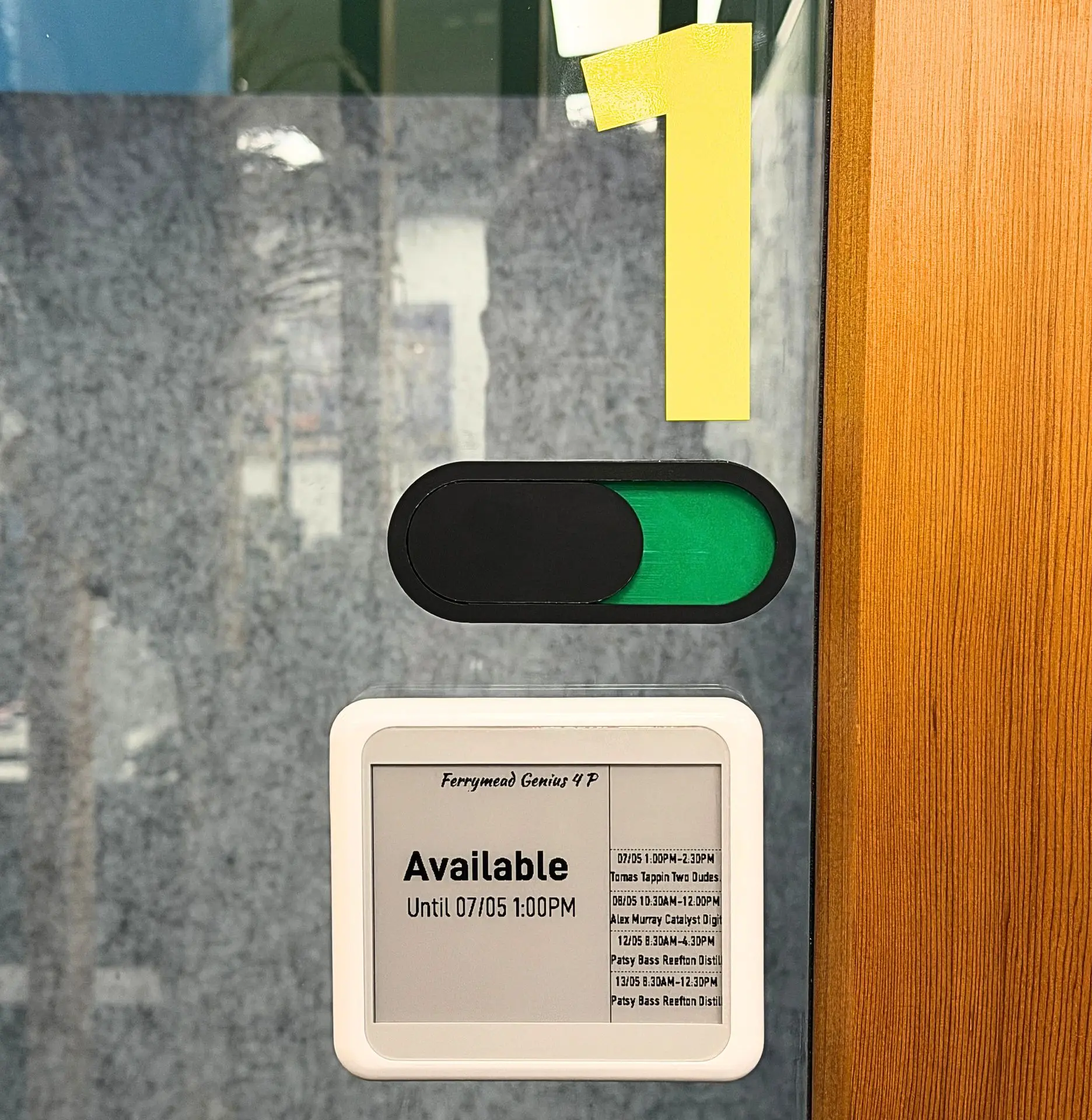 SyncSign display installed beside a meeting-room door